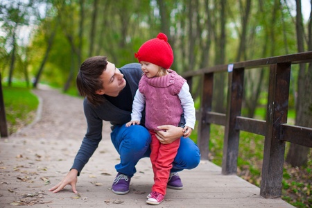 Portrait of Young father walking with his little cute daughter in autumn parkの写真素材