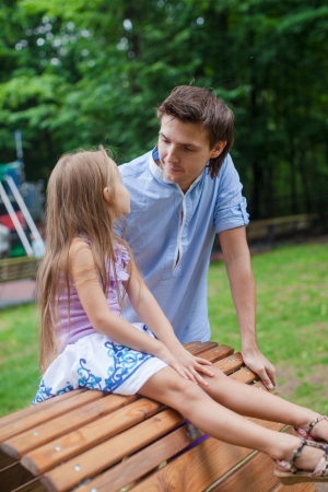 Portrait of father with his daughter on the wooden chairの写真素材