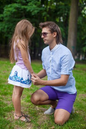Young happy father talking with cute daughter in the parkの写真素材
