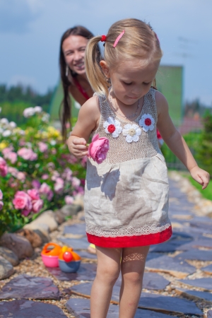 Young mother with her cute daughter have fun in the garden summer timeの写真素材