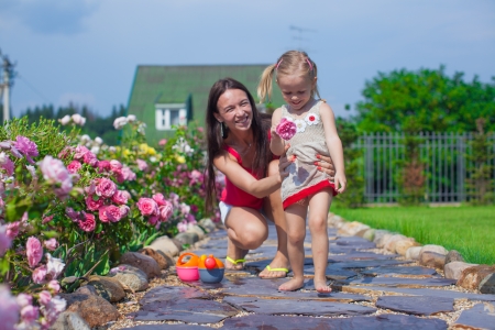Young mother with her cute daughter have fun in the garden summer timeの写真素材