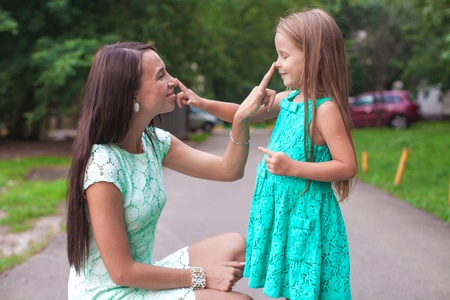 Happy young mother and her daughter having fun outdoorsの写真素材