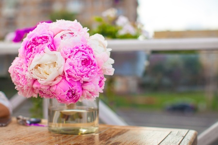 Charming bouquet of peonies in vase on table in restaurantの写真素材