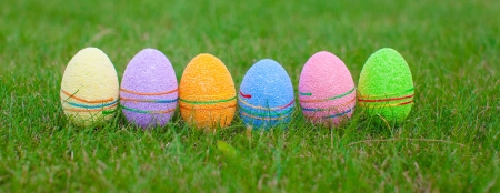 Multi-colored Easter eggs on green grassの写真素材