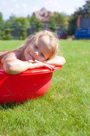 Portrait of smiling charming little girl enjoying her vacation in the pool outdoorsの写真素材