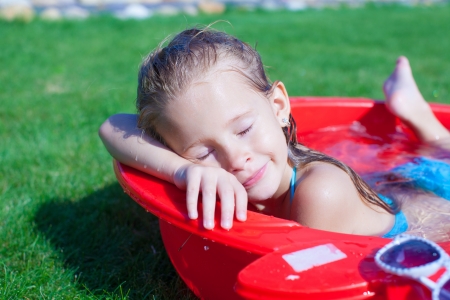 Closeup of Cute little girl enjoying her vacation in the pool outdoorsの写真素材