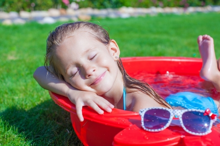 charming little girl enjoying her vacation in the pool outdoorsの写真素材
