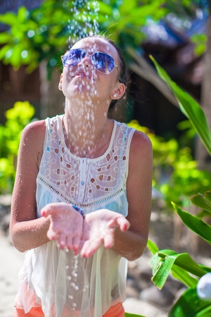 Young woman in tropical shower on exotic resortの写真素材