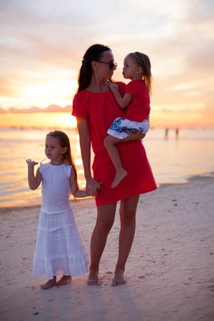 Mom and daughters silhouette in the sunset at the beach on Boracayの写真素材