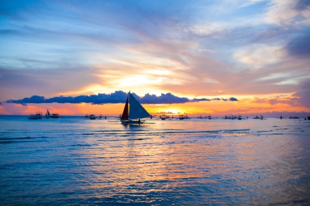 Small sailboat on the stunning sunset in the Philippinesの写真素材
