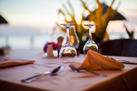 Close-up empty wine glass on the set table at sunsetの写真素材