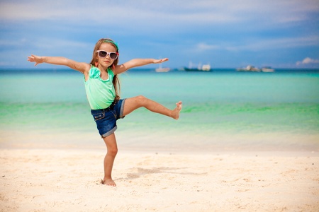 Beautiful little girl having fun on an exotic beachの写真素材