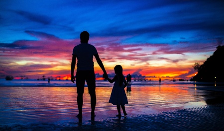 Father and daughter silhouettes in the sunset on the beach on Boracayの写真素材