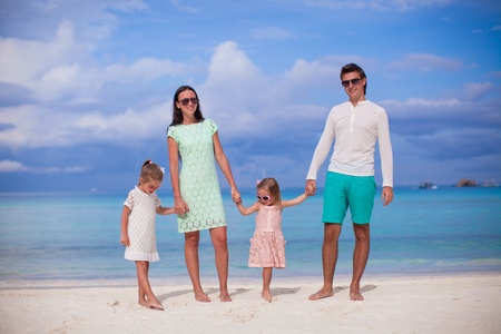 Fashion family of four walking by the sea and enjoy beach vacationの写真素材