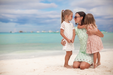 Fashion mother and two her adorable daughters at exotic beach on sunny dayの写真素材