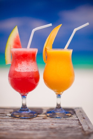 Close up fresh watermelon and mango cocktails on the background of stunning turquoise seaの写真素材