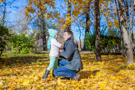Happy father and little girl in autumn parkの写真素材