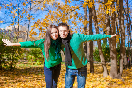 Happy family of two having fun in autumn park on a sunny fall dayの写真素材