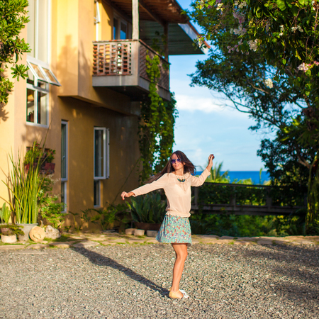 Young brunette woman relaxing in the courtyard of beautiful houseの写真素材