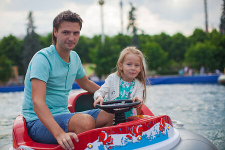 Young dad and his little girl riding on an airboat in the attraction