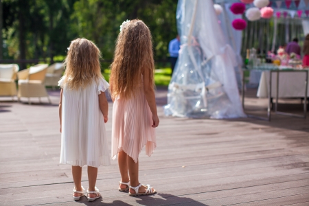 Two cute little girls in beautiful dresses on the wedding ceremonyの写真素材