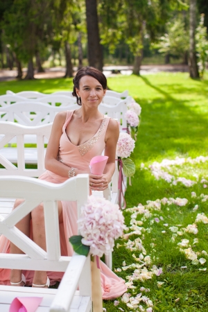 Beautiful young girl in a long dress at the ceremony outdoorsの写真素材