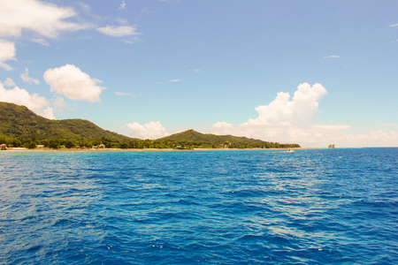 Waves from boats and view of the island of Maheの写真素材
