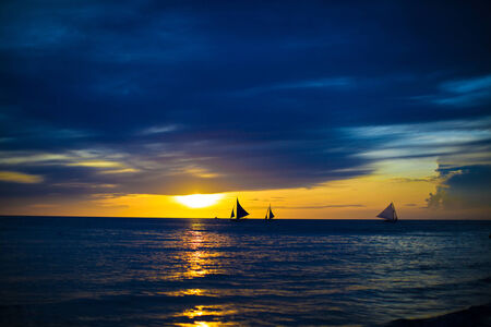 Small sailboats on the beautiful sunset in the Philippines