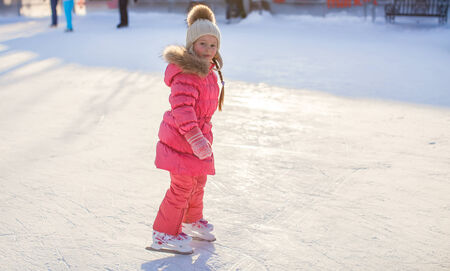 Adorable little girl enjoying skating at the ice-rinkの写真素材