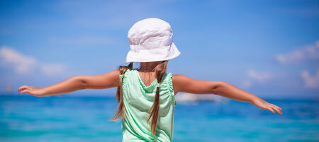 Little happy girl on a tropical beach with turquoise waterの写真素材