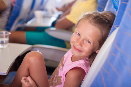 Little smiling happy girl in the airplaneの写真素材