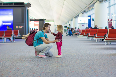 Little girl and young dad in the airport waiting for a flightの写真素材