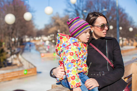 Little girl with her mother walking on a sunny day outdoorsの写真素材