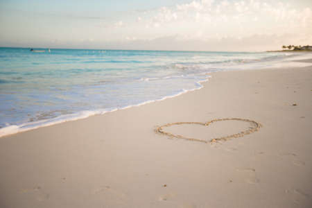 Heart painted in the sand on a tropical beach