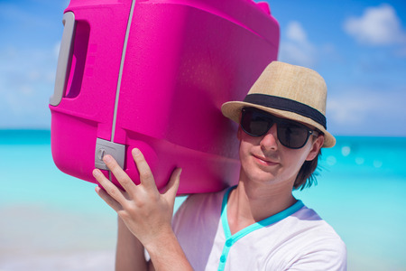 Close-up of young man carrying his luggageの写真素材