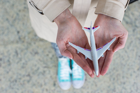 Close up hand holding an airplane model background the airport