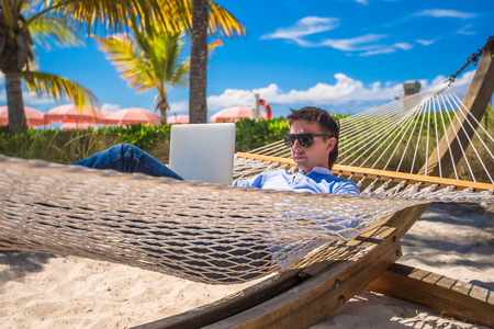 Young man using laptop on the beachの写真素材