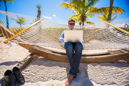 Young man using laptop on the beachの写真素材
