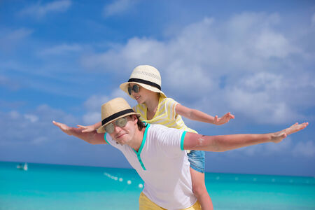 Young father and his adorable little daughter have fun at tropical beachの写真素材