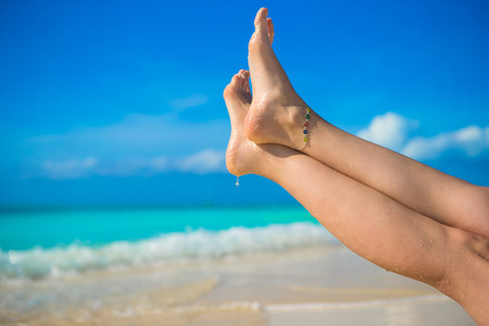 Close up of female feet on white sand beachの写真素材