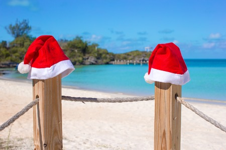 Close-up santa hat on fence on tropical white caribbean beachの写真素材