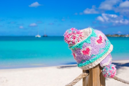 Close-up santa hat on fence on tropical white caribbean beachの写真素材
