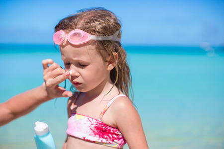 Child protection sun cream on the beachの写真素材