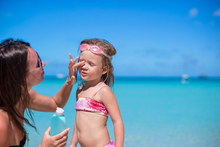 Child protection sun cream on the beachの写真素材