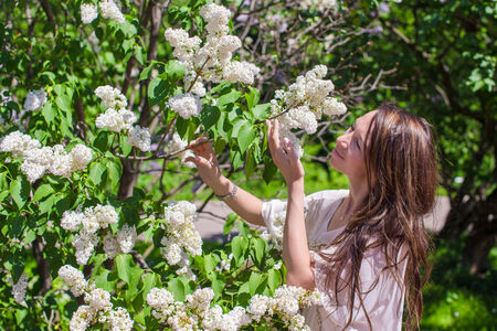 Young attractive woman in white lilac gardenの写真素材