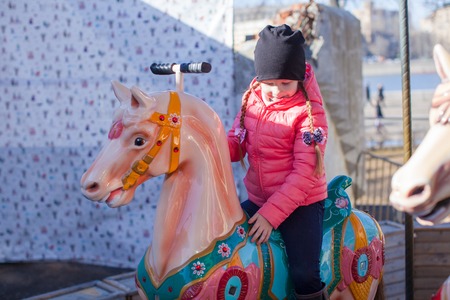 Little girl on carousel at an amusement parkの写真素材