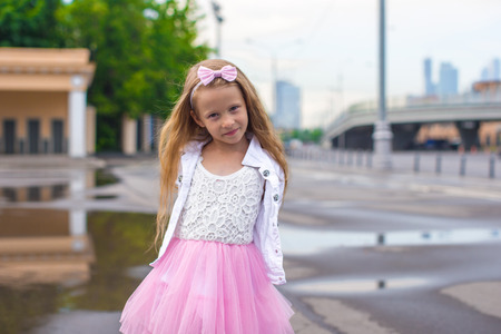 Fashion happy beautiful little girl outdoor aloneの写真素材