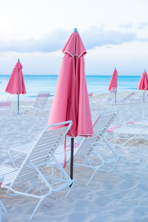 Paradise view of nice tropical empty sandy plage with umbrella and beach chairの写真素材