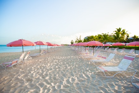 Paradise view of nice tropical empty sandy plage with umbrella and beach chairの写真素材