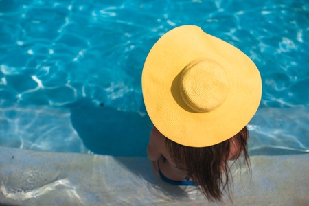 Young beautiful woman enjoying vacation in the swimming poolの写真素材